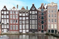 阿姆斯特丹狭窄运河边的标志性房屋，展现了独特的建筑景观
