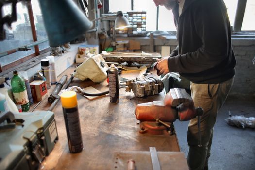 A skilled mechanic repairing machinery in a well-equipped workshop.