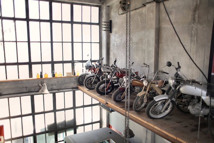 Retro motorbikes parked in row on special platform in garage