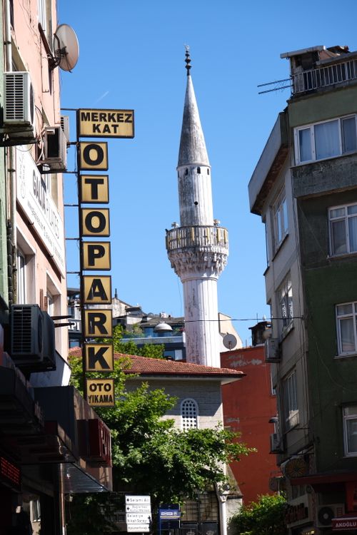 Free Street view featuring a minaret with clear blue skies, displaying Turkish architecture. Stock Photo