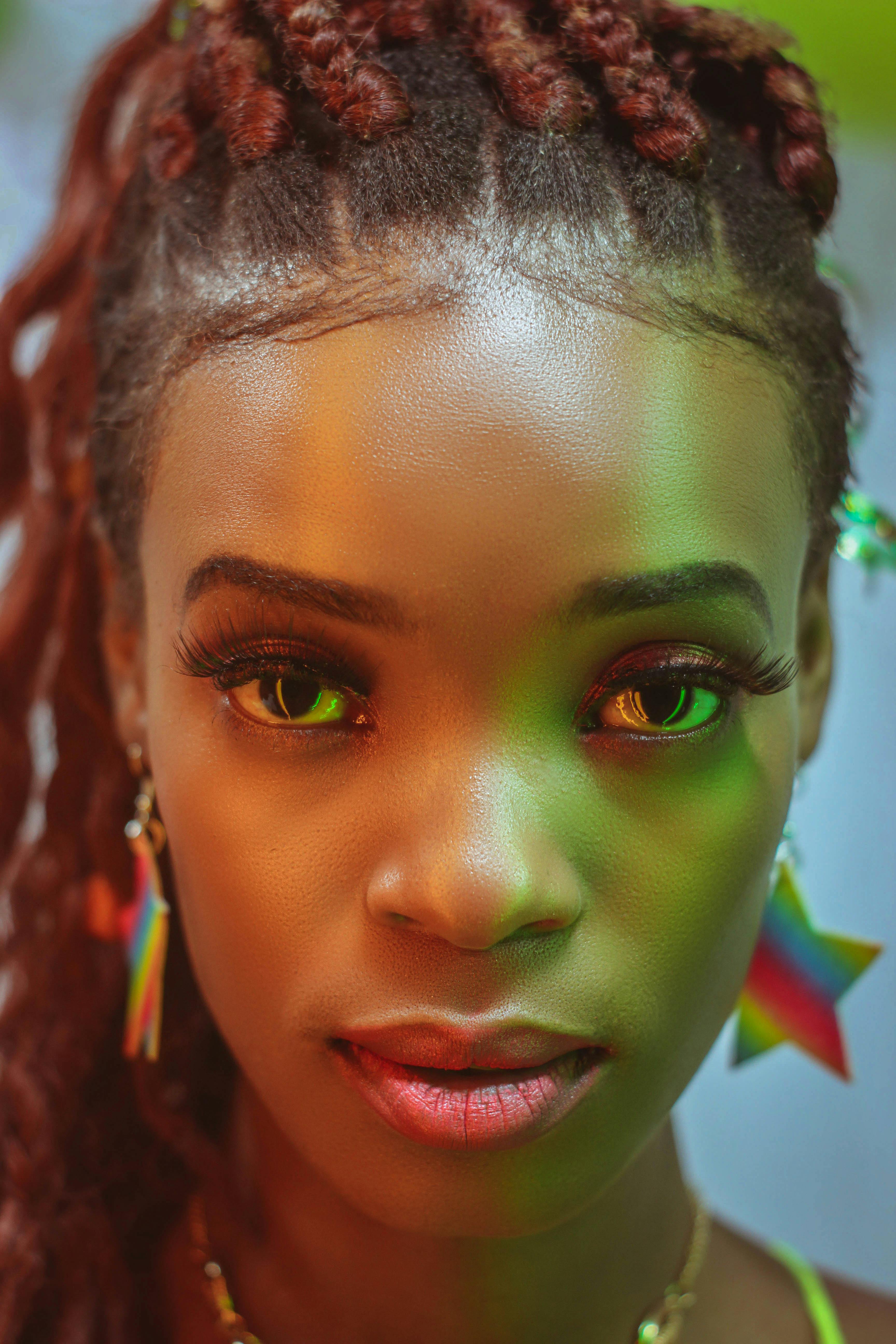 特写镜头里，一位女性梳着辫子，戴着充满活力的耳环，置身于色彩缤纷的灯光中