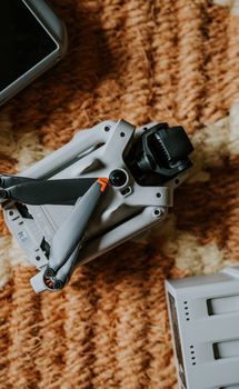 Close-up of a folded drone on a textured rug, showcasing modern technology.