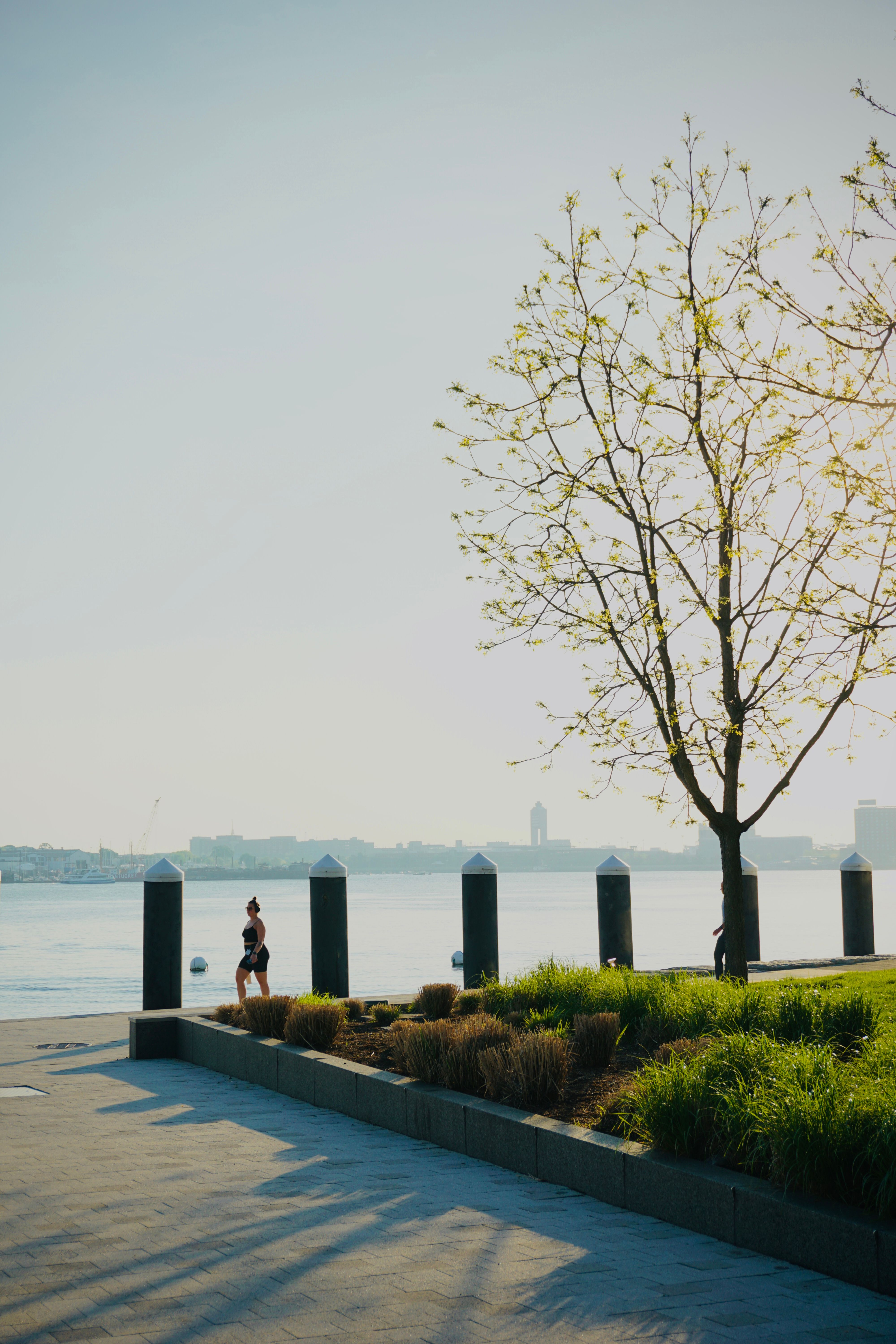 Two people jogging along a riverside path on a sunny spring morning.