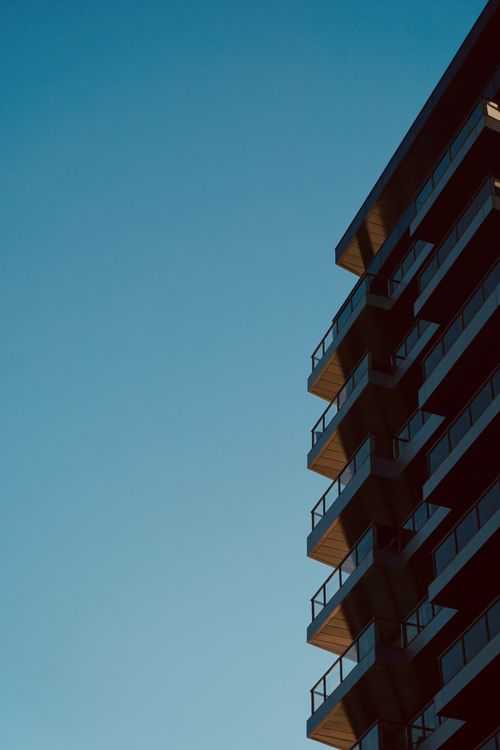 Free A contemporary high-rise building set against a clear blue sky, showcasing urban architecture. Stock Photo