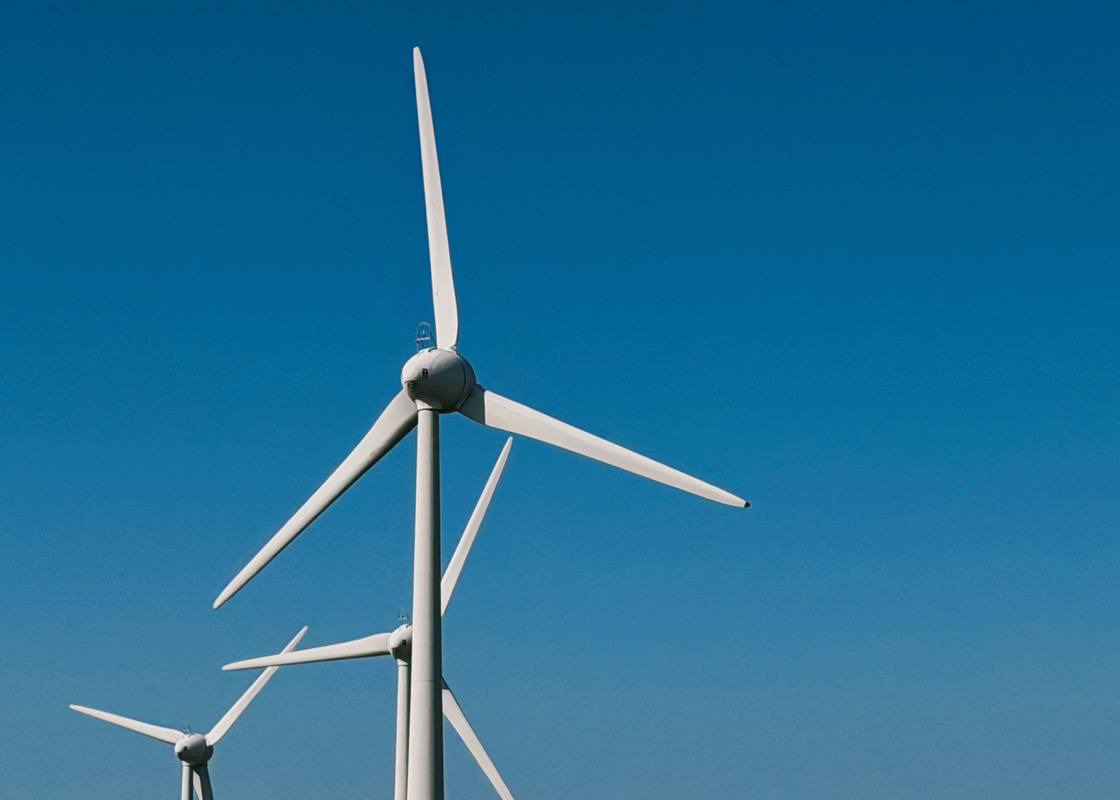 Painéis de aerogeradores contra um céu claro, simbolizando energia renovável e sustentabilidade.