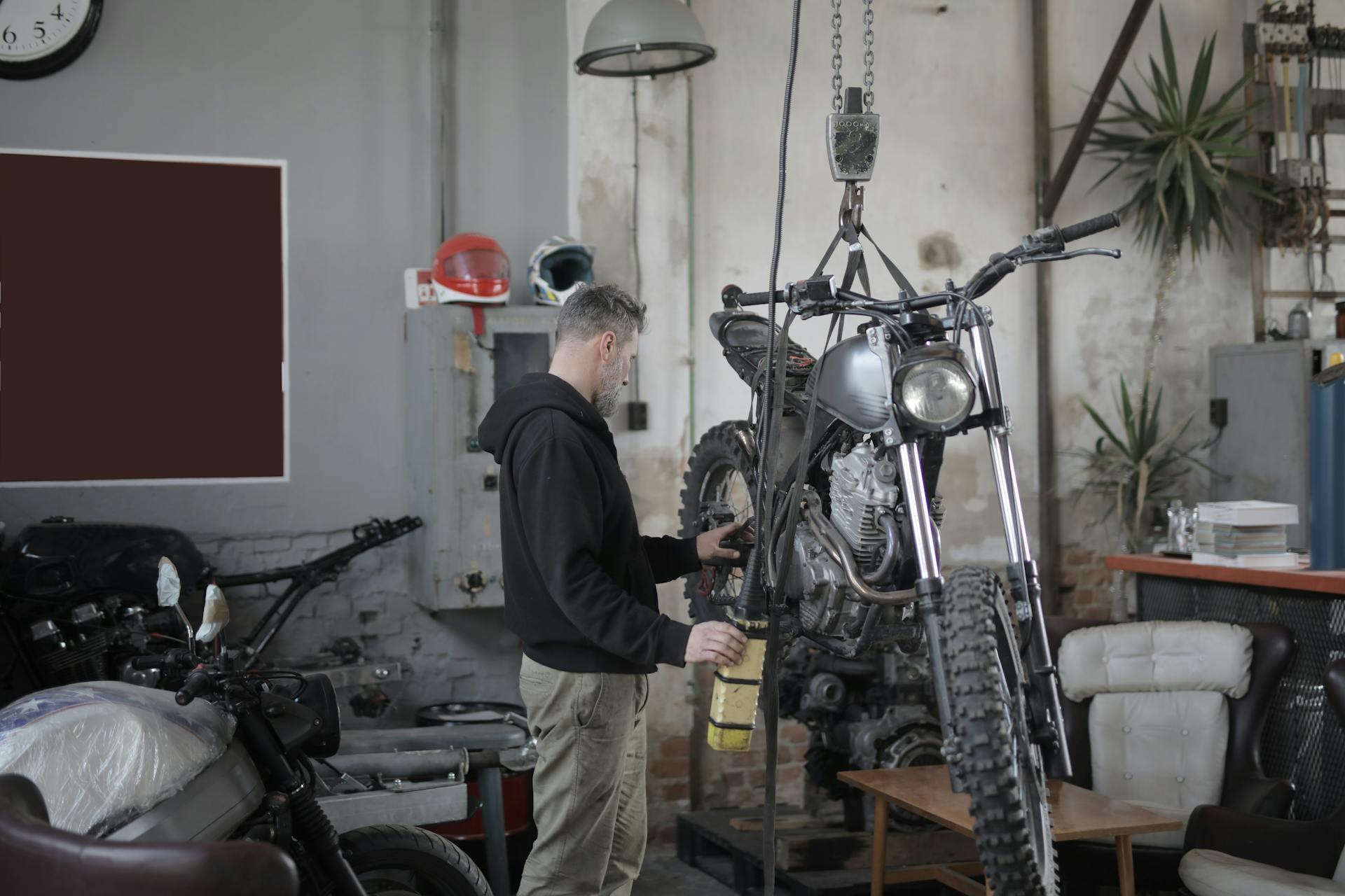 Man in Black Jacket Standing Beside Black Motorcycle