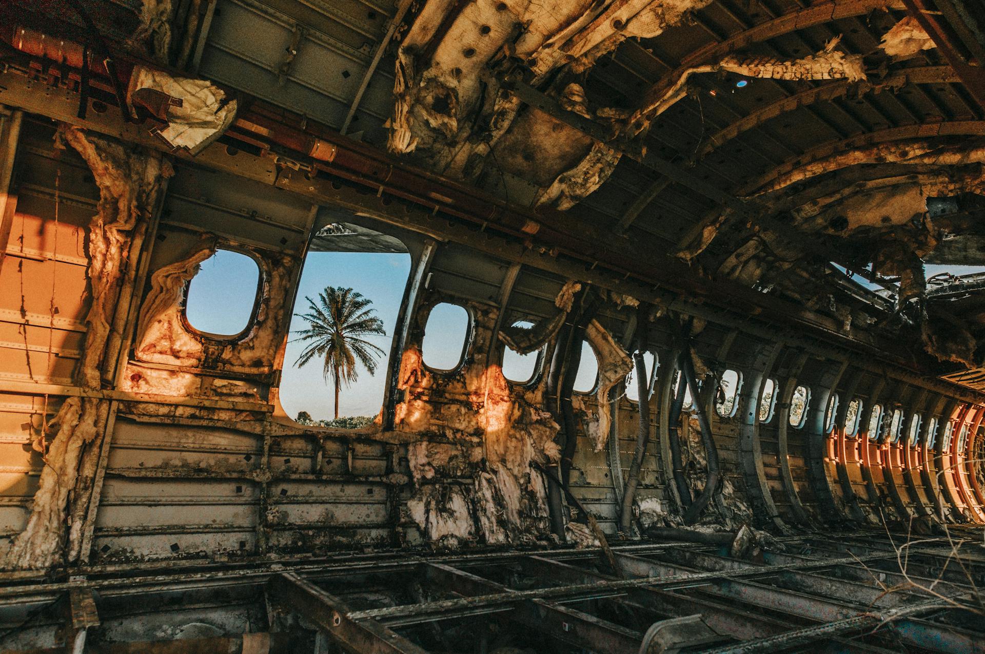 Damaged aircraft cabin interior at colorful sunset