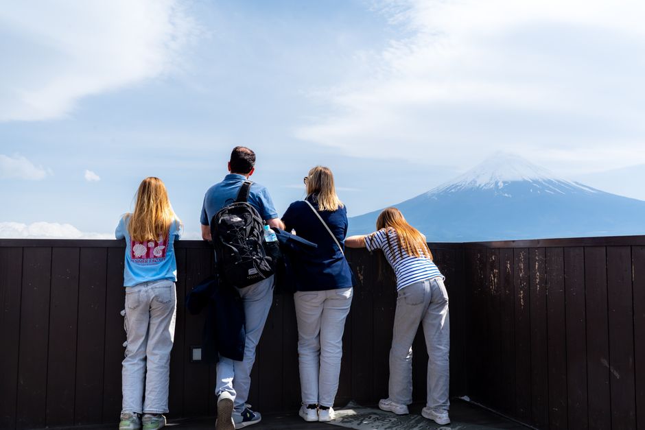日本の富士宮市から富士山を眺める観光客グループ。晴天で、美しい山の景色が広がっている。