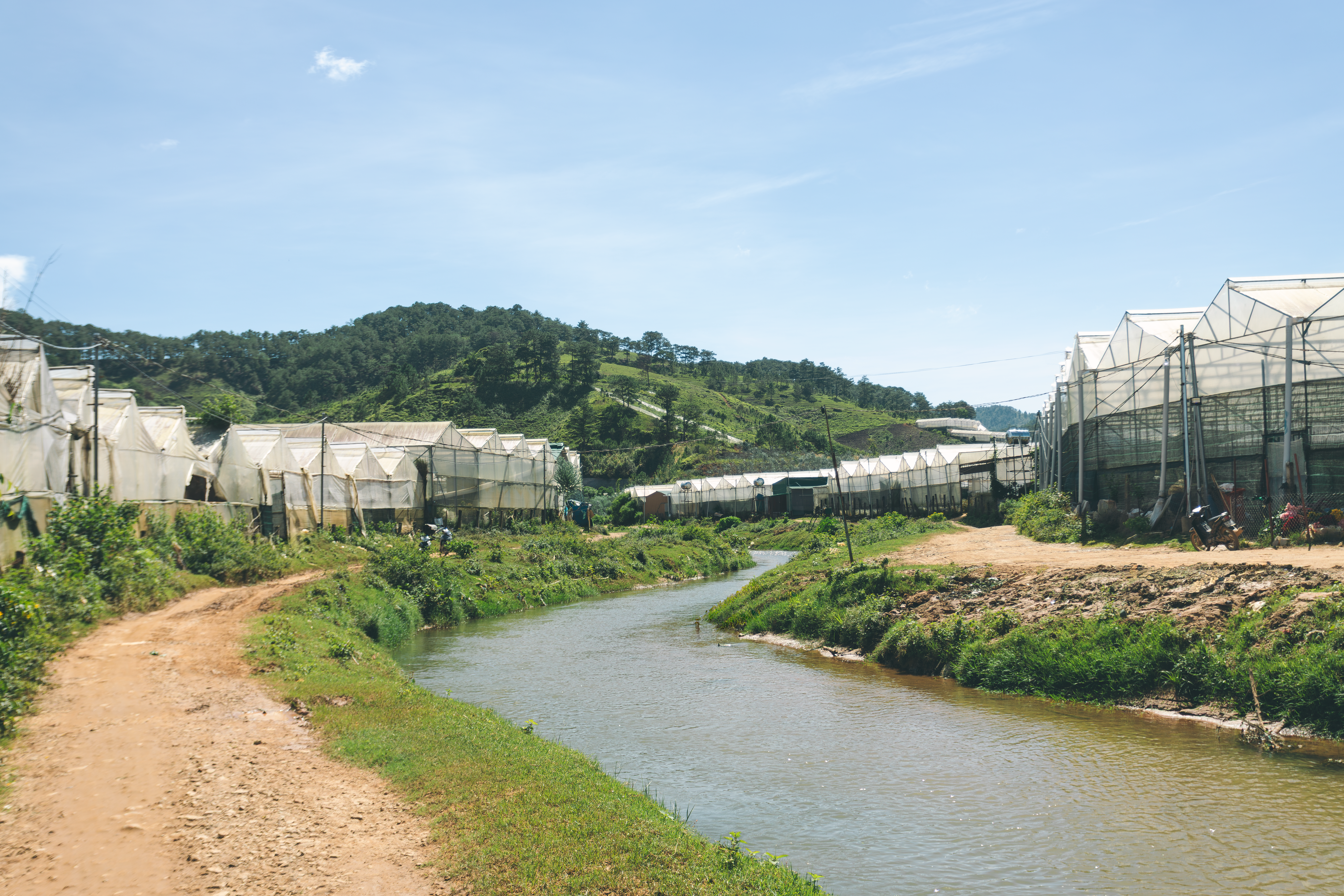 Scenic view of greenhouses beside a river in the countryside of Lạc Dương, Việt Nam.