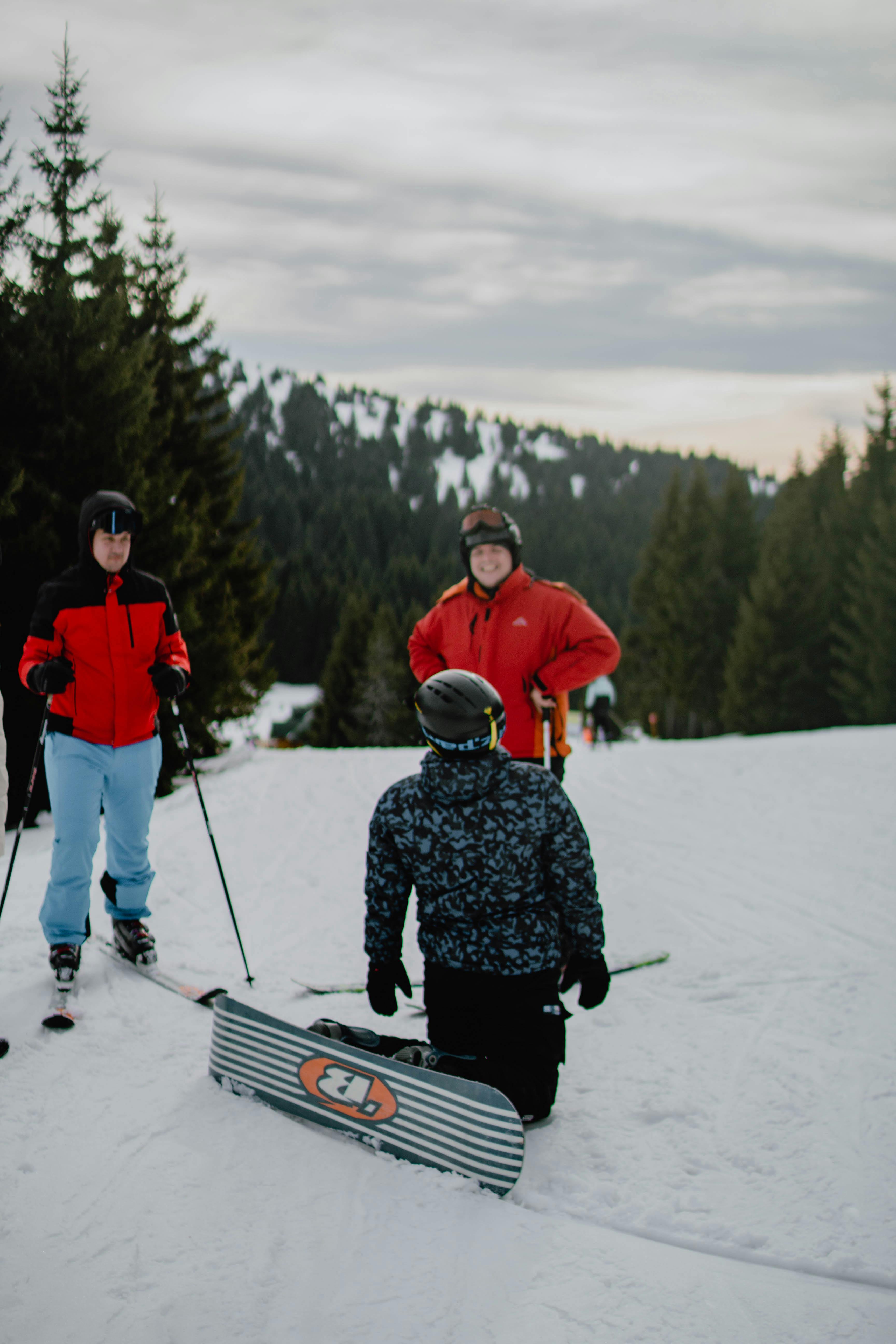 friends spending time together with skis and snowboard in winter