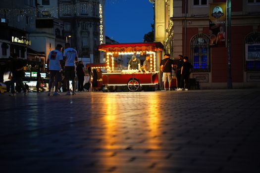 A nighttime scene of a lively street vendor in a bustling square in Istanbul, showcasing vibrant city life.