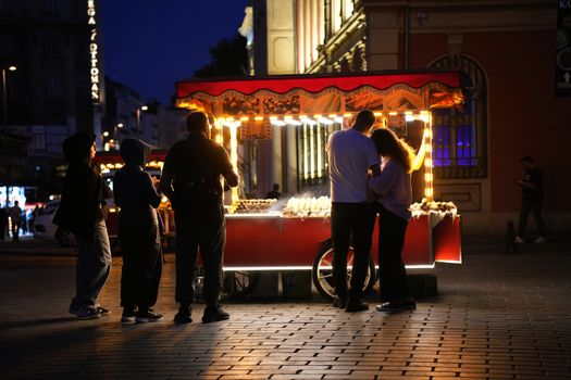 A lively street food vendor at night in Istanbul with people gathering around.