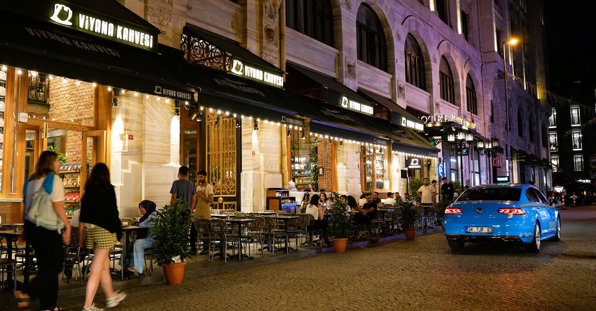 A vibrant night scene at Viyana Kahvesi, Istanbul, showcasing city life and dining culture.