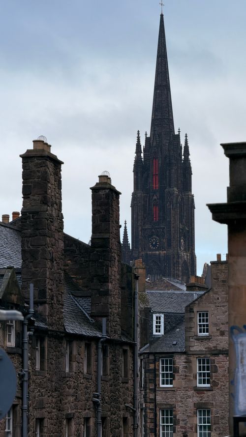 Free View of Edinburgh's historic architecture with a prominent church spire visible against the cityscape. Stock Photo