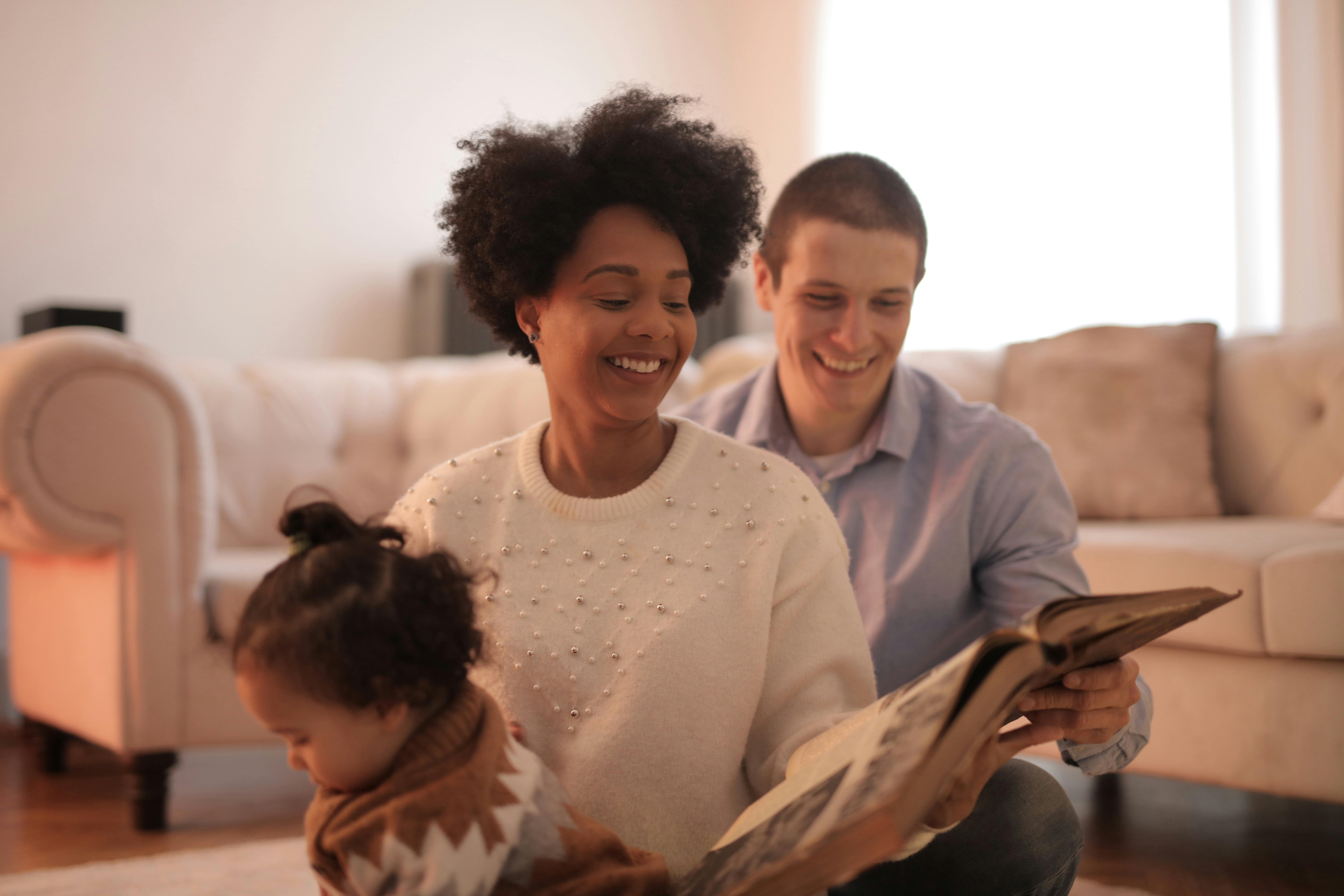 photo of man and woman smiling while holding a book