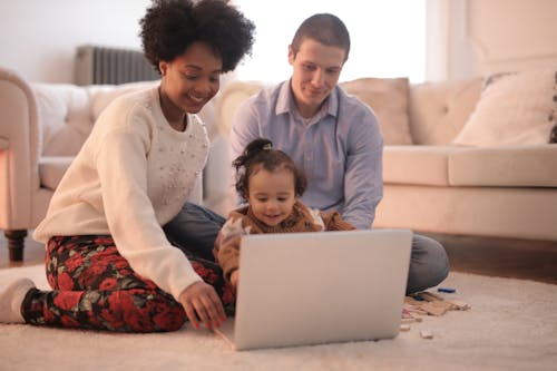 Foto Di Famiglia Seduta Sul Pavimento Durante L'utilizzo Di Laptop