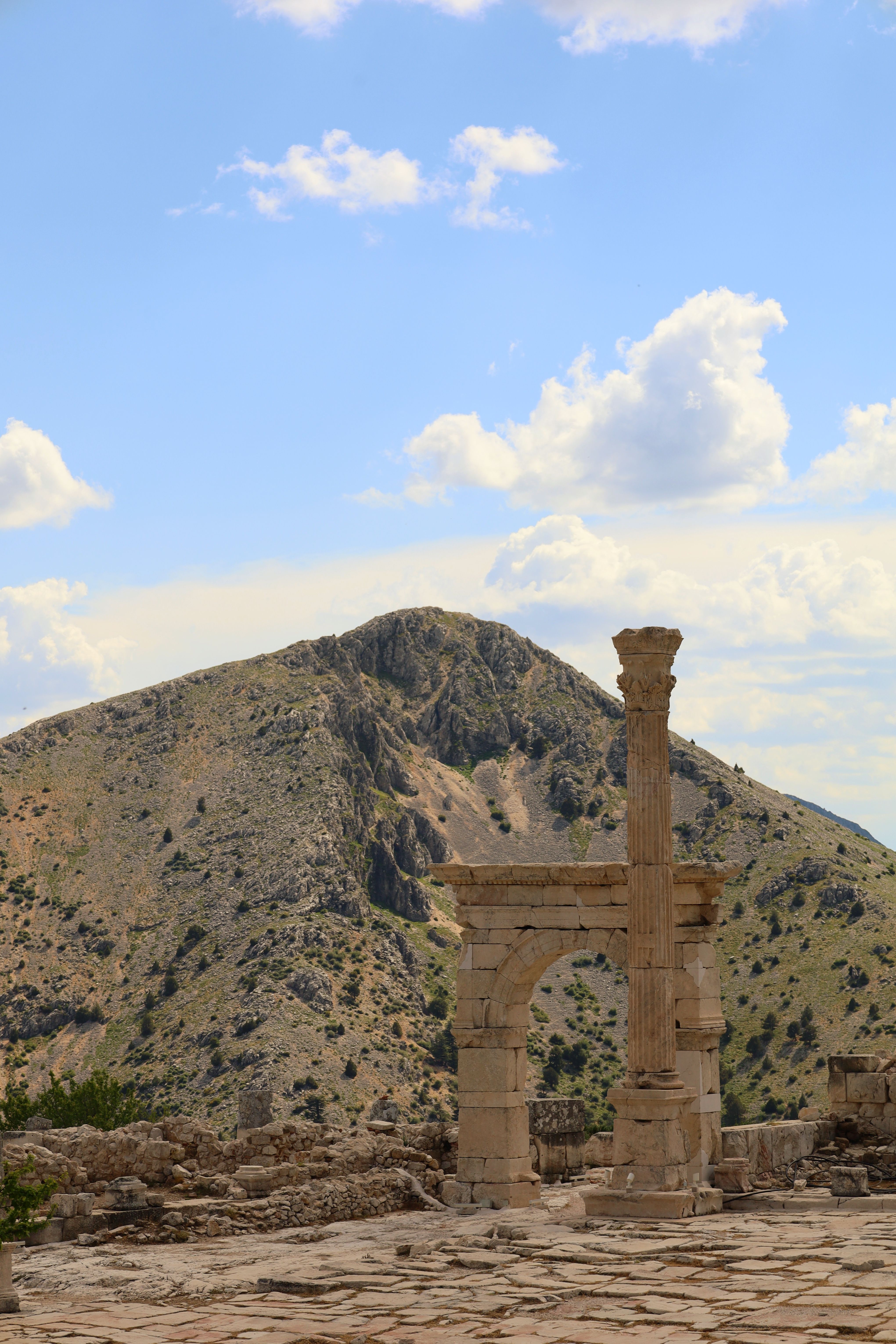Explore the stunning ancient ruins of Burdur, Türkiye, with mountainous backdrops under a bright sky.
