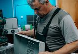 Repair technician examining a home appliance indoors