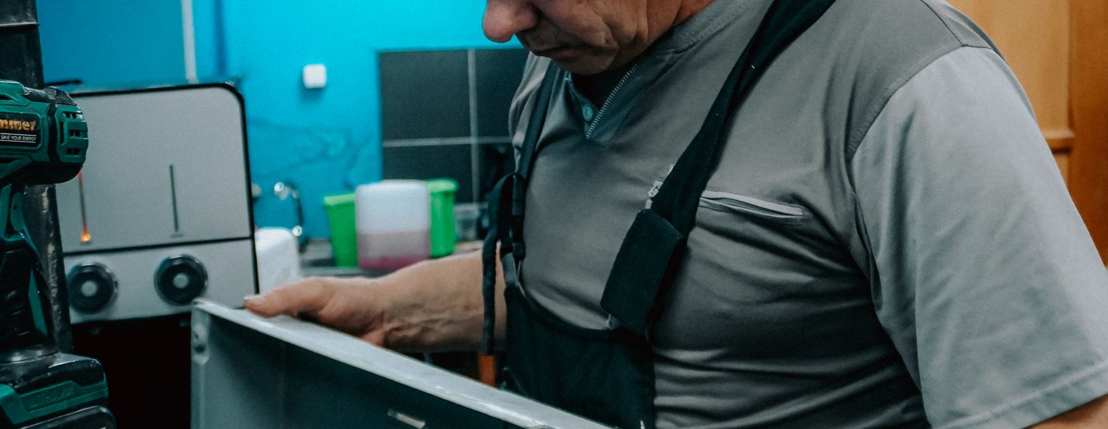 Repair technician examining a home appliance indoors