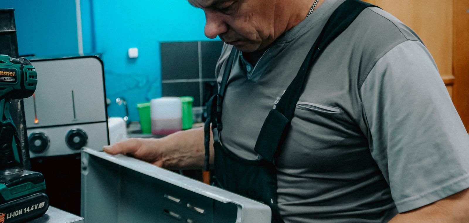 Repair technician examining a home appliance indoors