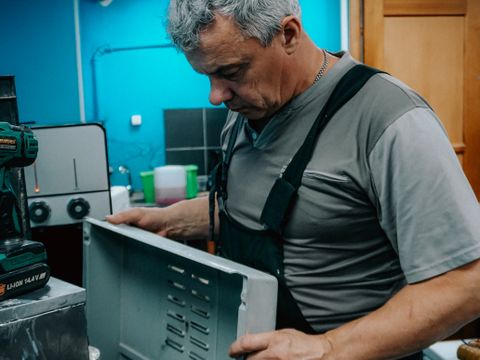 Repair technician examining a home appliance indoors