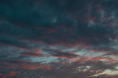 Free A moody evening sky featuring dramatic clouds and vibrant sunset colors. Stock Photo