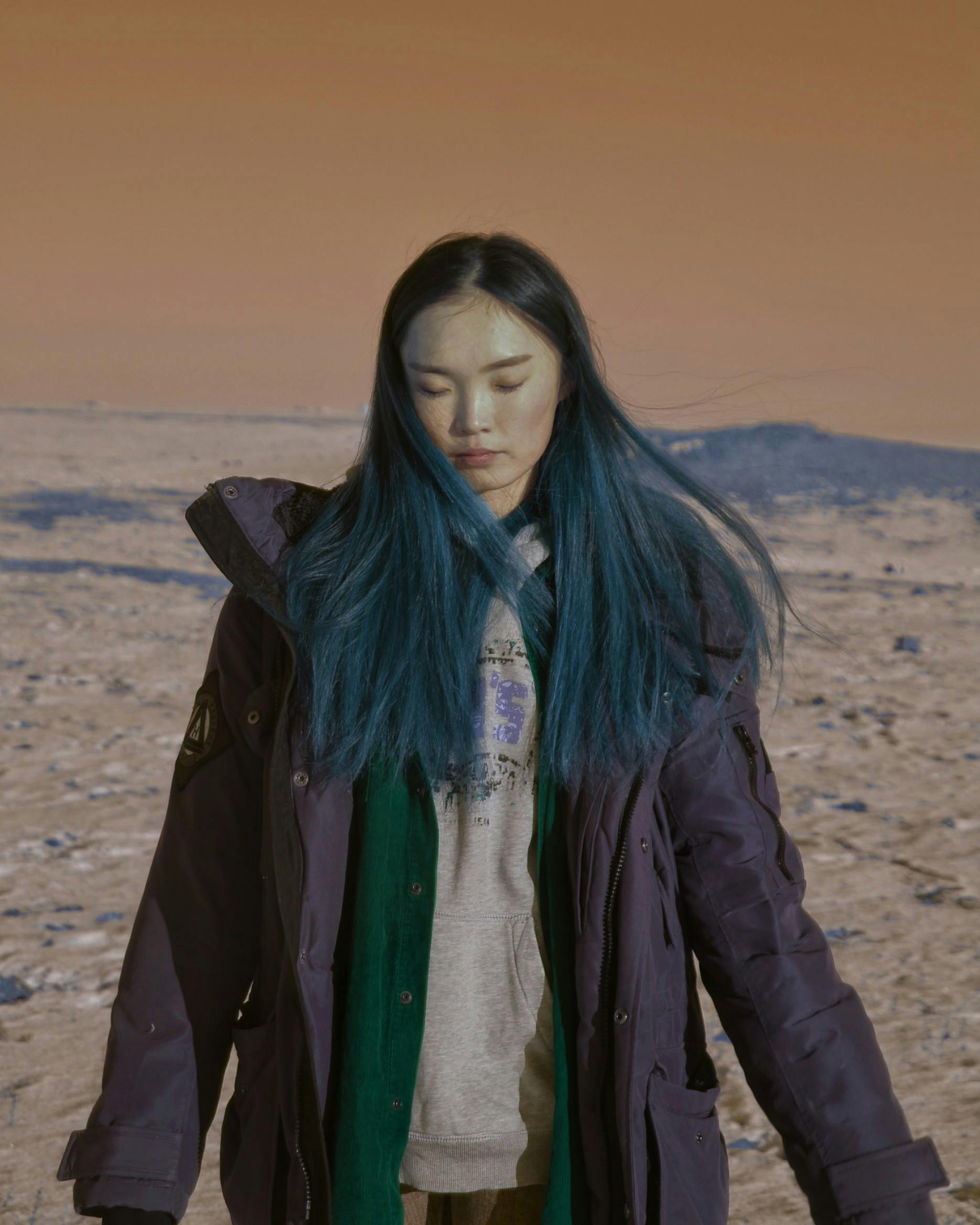 Woman in Black Jacket Standing on Brown Sand