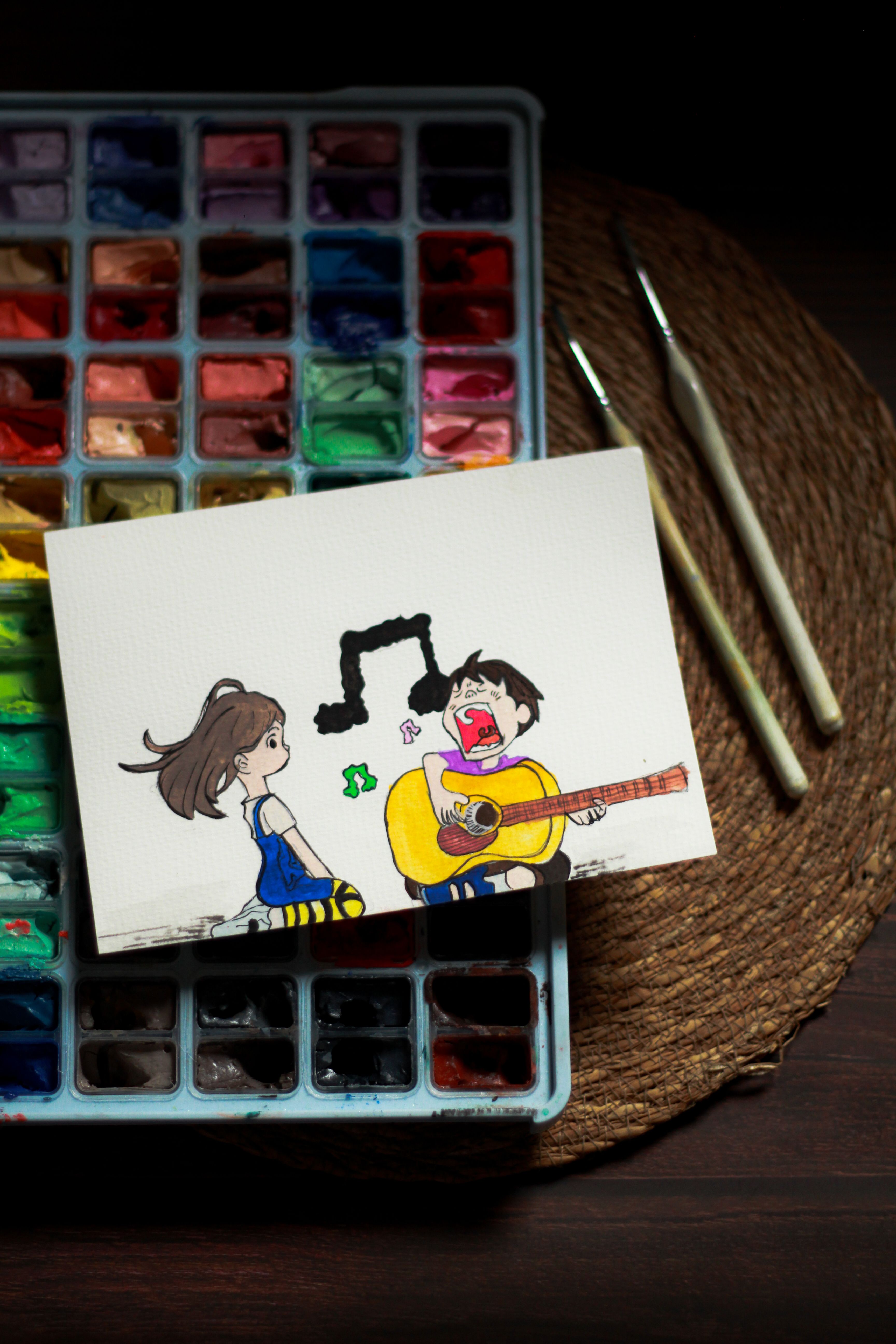 Artistic illustration of cartoon characters with a guitar on a watercolor palette.