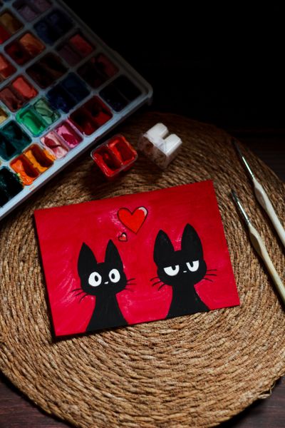 Hand-painted black cats on a red mini canvas — photo by Tanha Tamanna Syed on Pexels