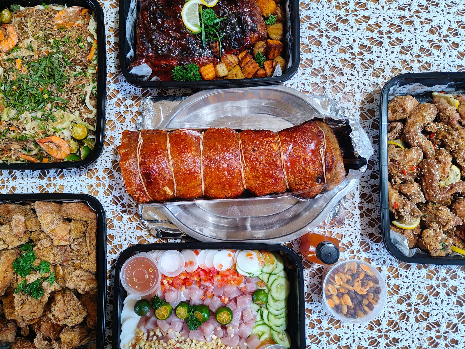An enticing spread of various Filipino dishes presented on a lace-covered table.