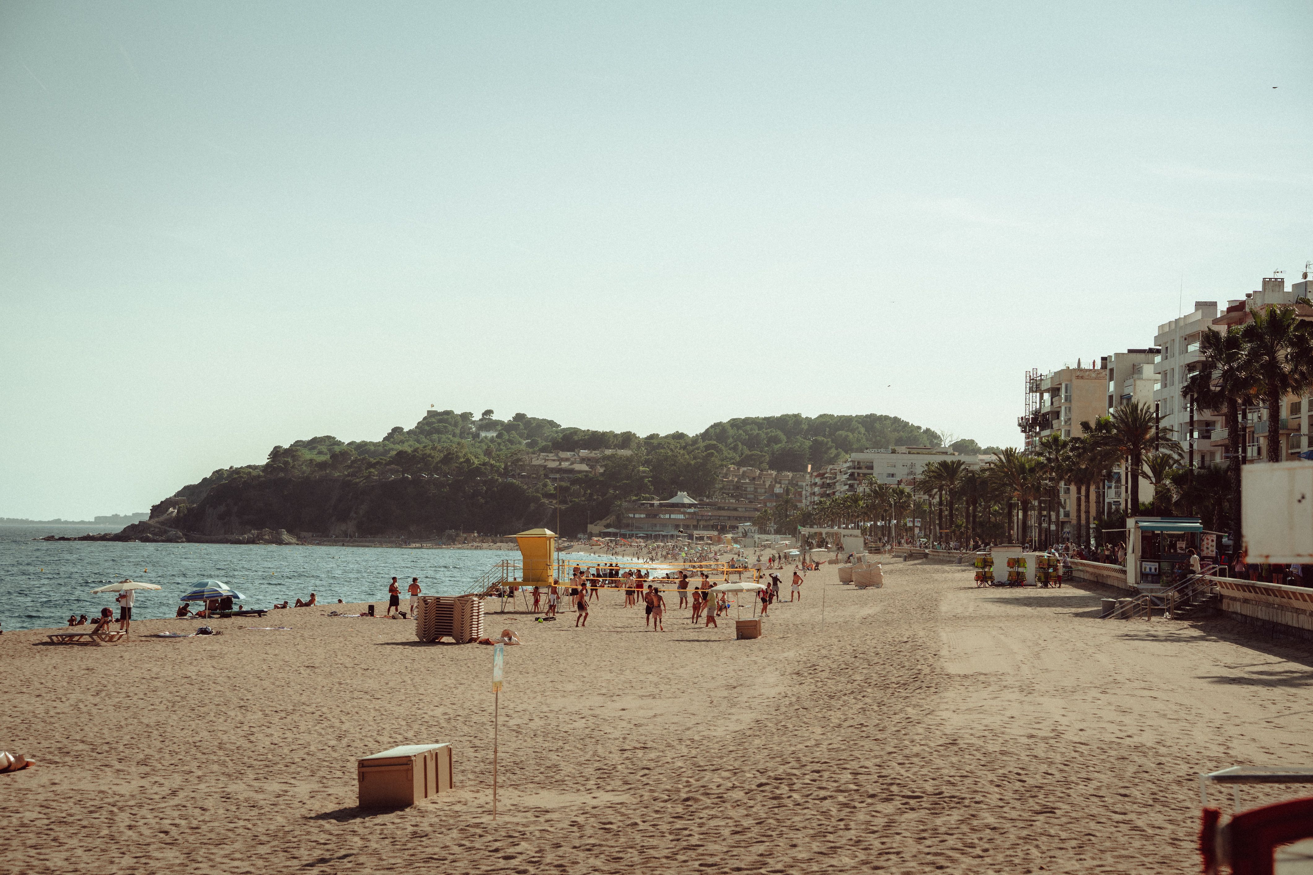 Scenic view of Lloret de Mar beach with people enjoying the sun and sea.
