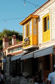 Charming street view of a cafe with a distinct yellow facade, perfect for a sunny day out.