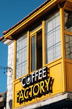 Vibrant yellow coffee shop facade with large sign and blue sky background.