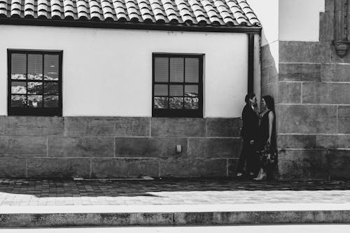 Photo of Couple Standing by the Concrete Building