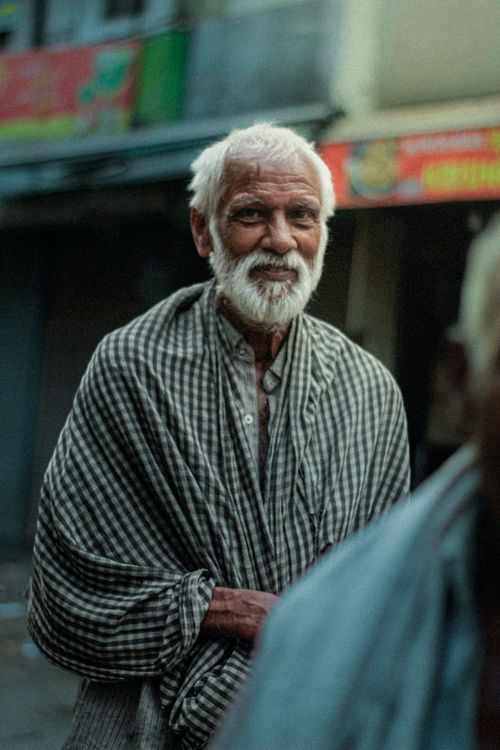 Free Elderly man with a beard wearing traditional clothing, captured outdoors in an urban setting. Stock Photo
