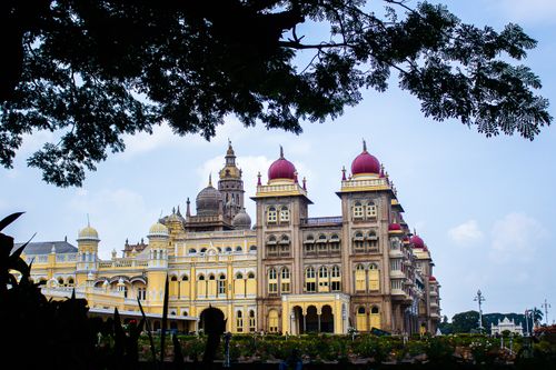 Free A stunning view of Mysore Palace, framed by lush foliage, showcasing its grand architecture. Stock Photo