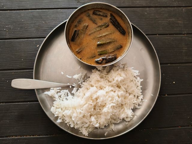 Aerial view of Indian sambar with rice on a metal plate, showcasing traditional South Indian cuisine.