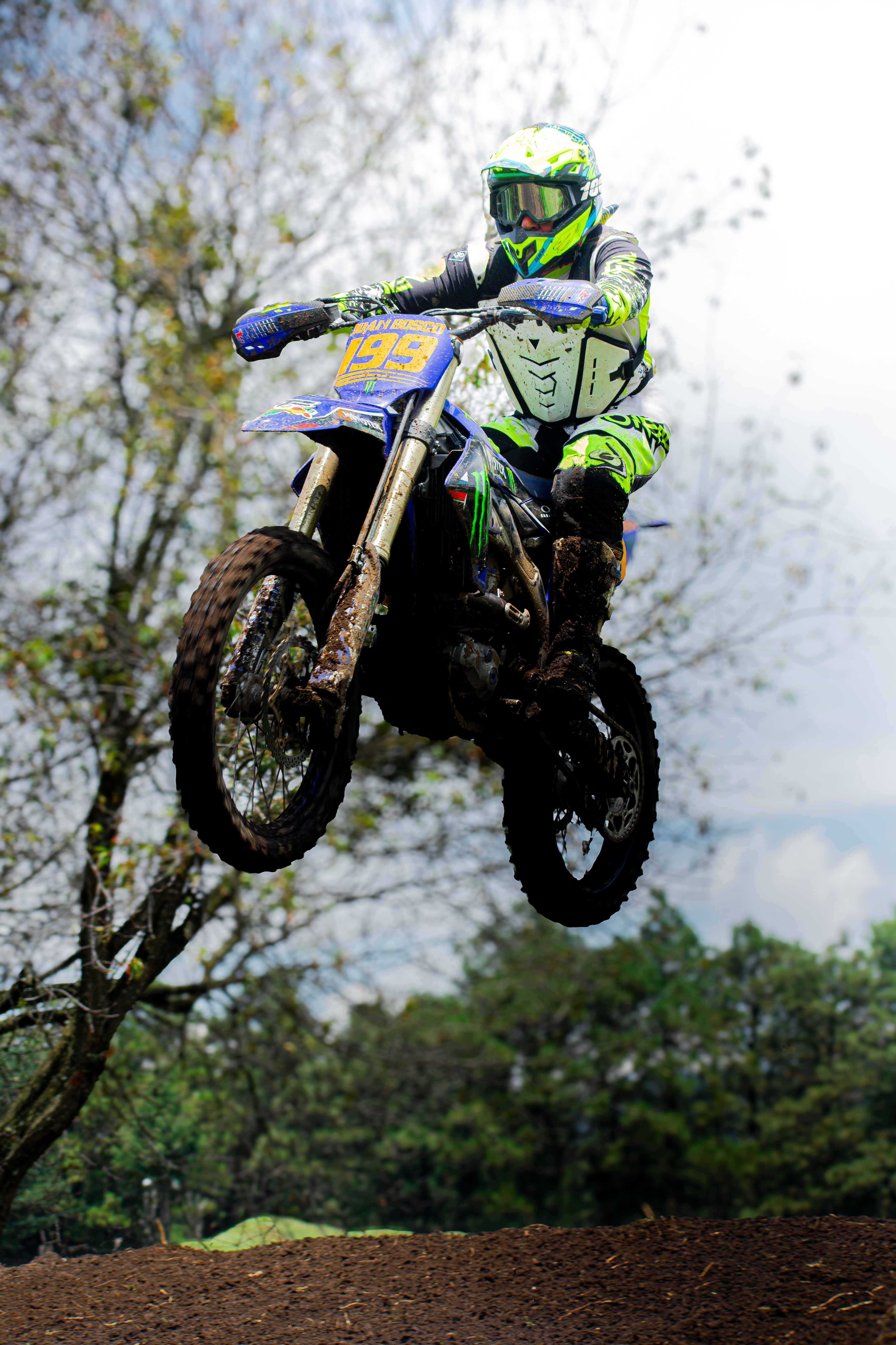 Thrilling motocross action shot featuring a rider mid-air during an outdoor race.