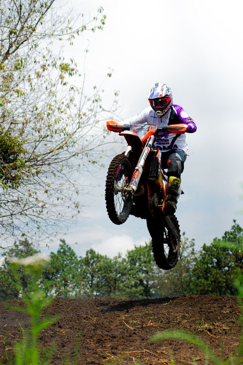 Free Dynamic motocross action with a motorcyclist performing a jump on a dirt track in Mexico. Stock Photo