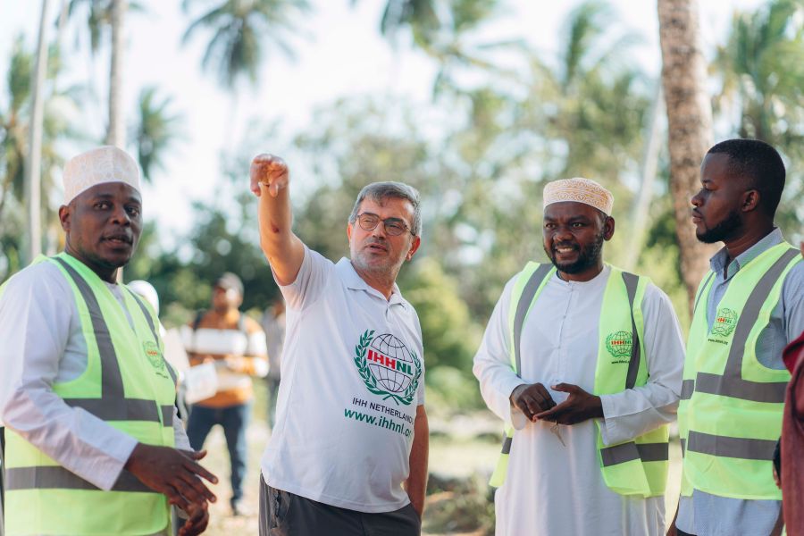 A group of adults in high-visibility vests coordinating outdoors