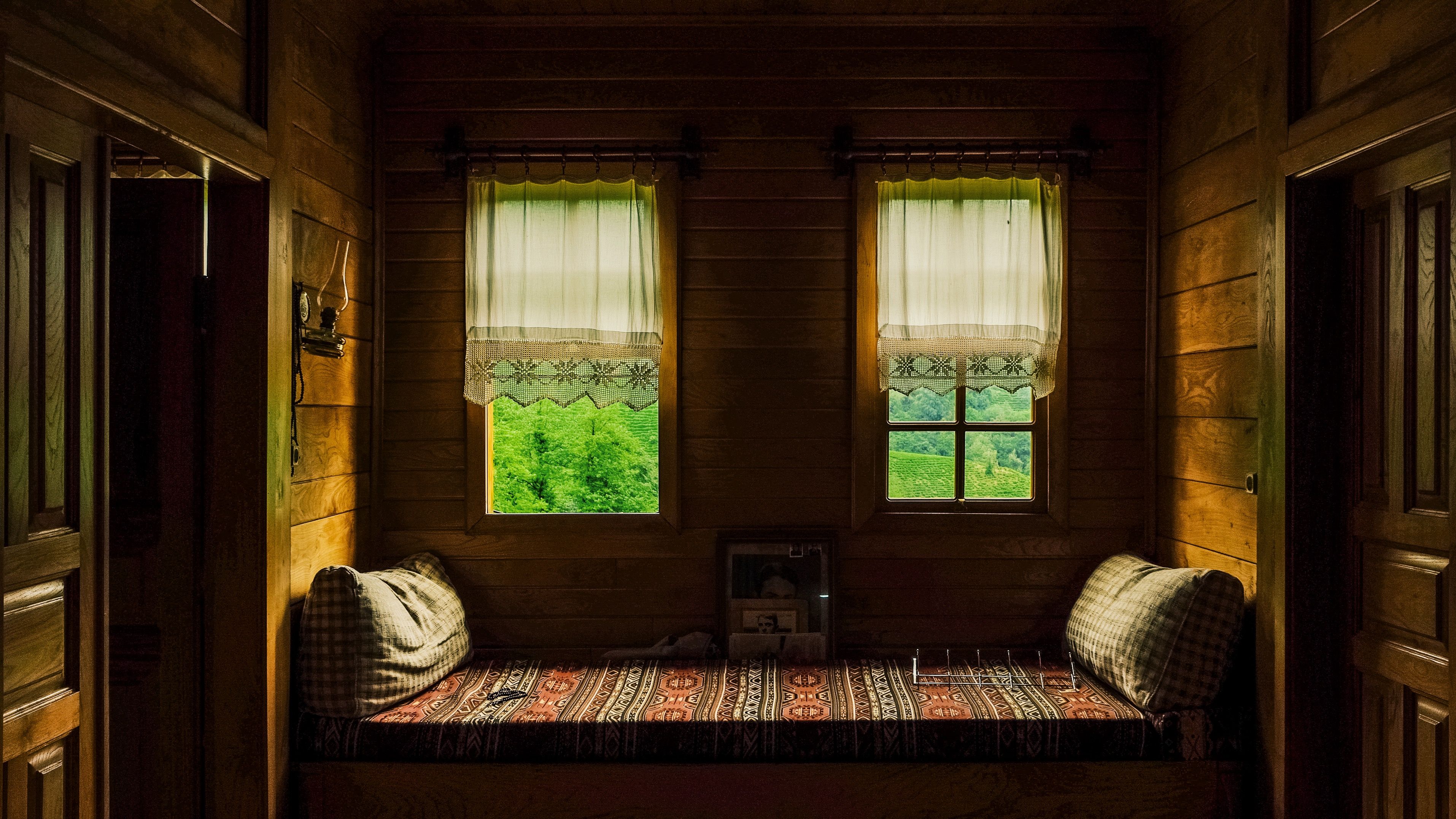 Warm wooden interior with a cozy sofa, showcasing Artvin\'s lush greenery through the windows.