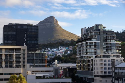 Free Scenic urban view of Cape Town with Lion's Head mountain in the background under a clear blue sky. Stock Photo