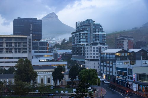 Free Scenic view of Cape Town city buildings with Lion's Head in the background during a cloudy day. Stock Photo