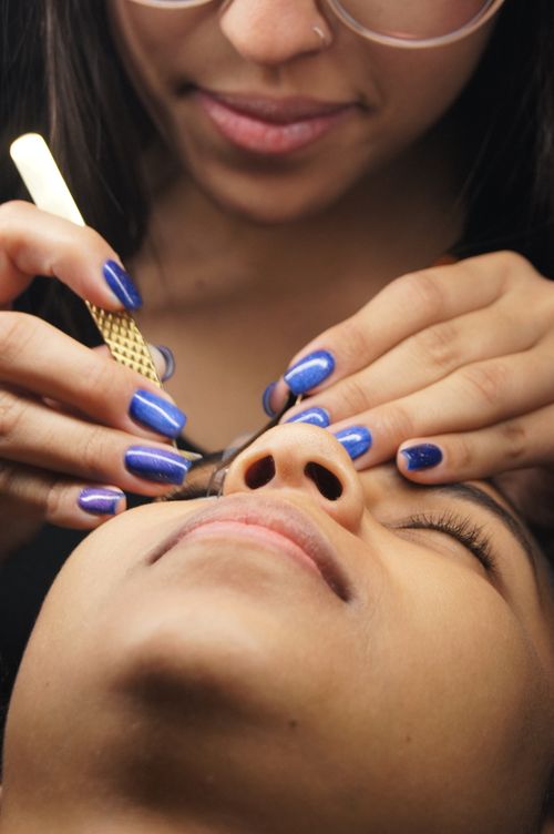 Free Close-up of an aesthetician threading a woman's eyebrows in a spa setting. Stock Photo