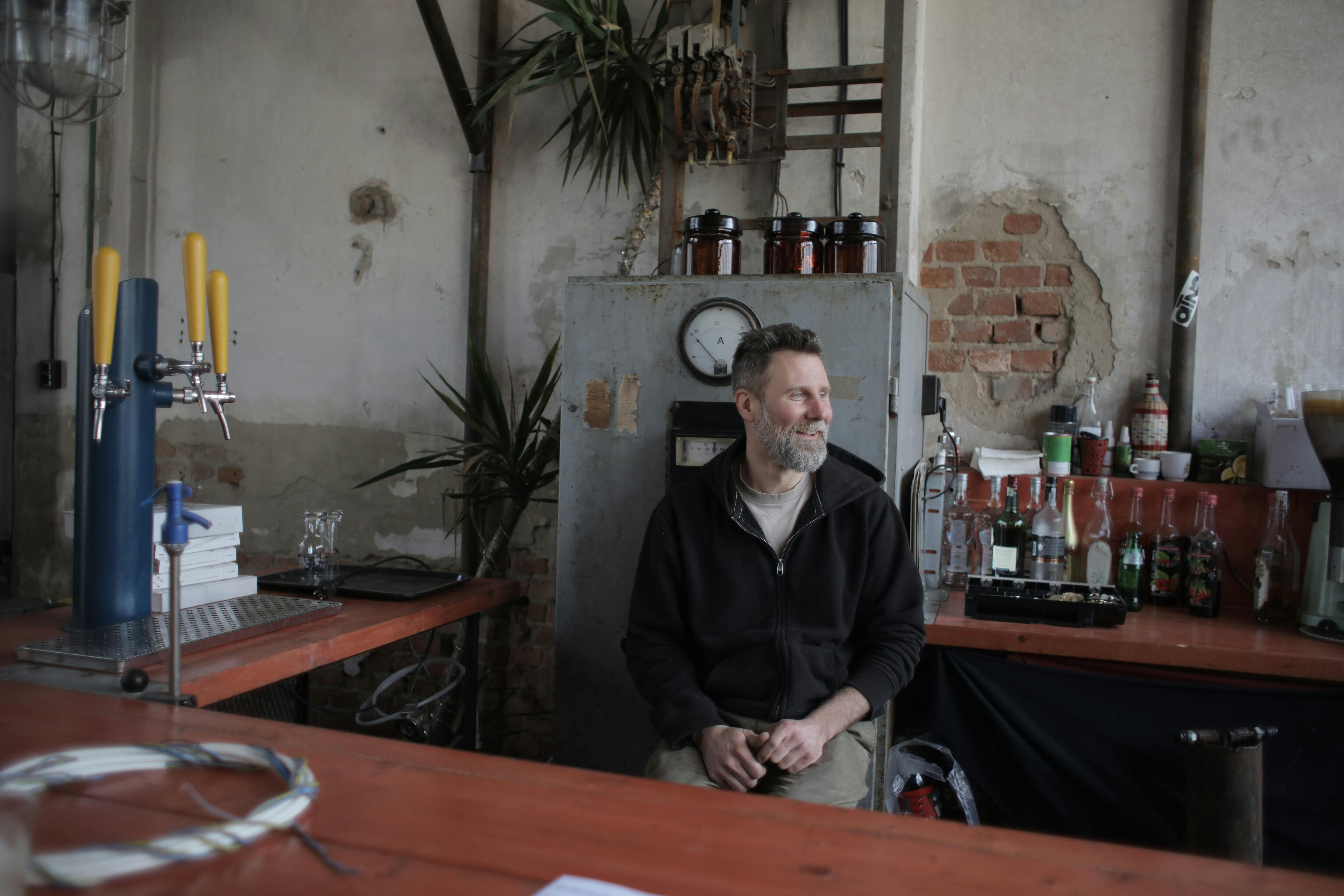 man in black jacket shirt sitting on chair