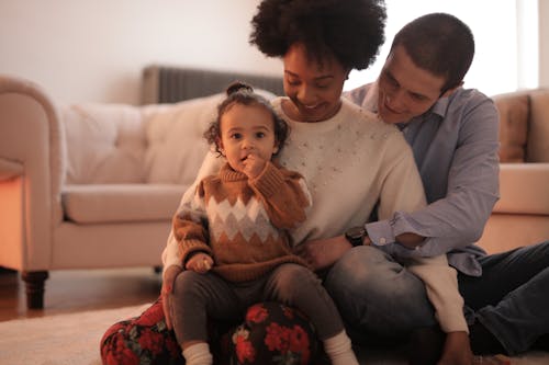 Photo of Kid Sitting on Her Mother's Lap