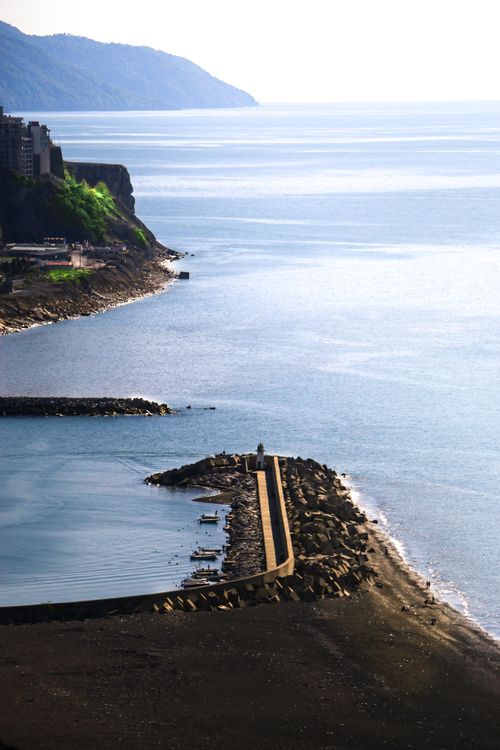 Free Majestic coastal view with cliffs and ocean waves under a bright sky. Stock Photo
