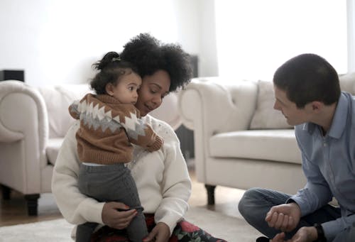 Toddler hugging black mother at home