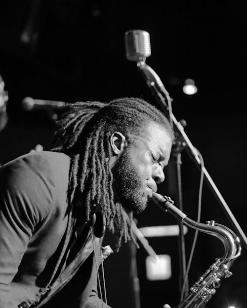 Grayscale Photo of Man Playing a Wind Instrument