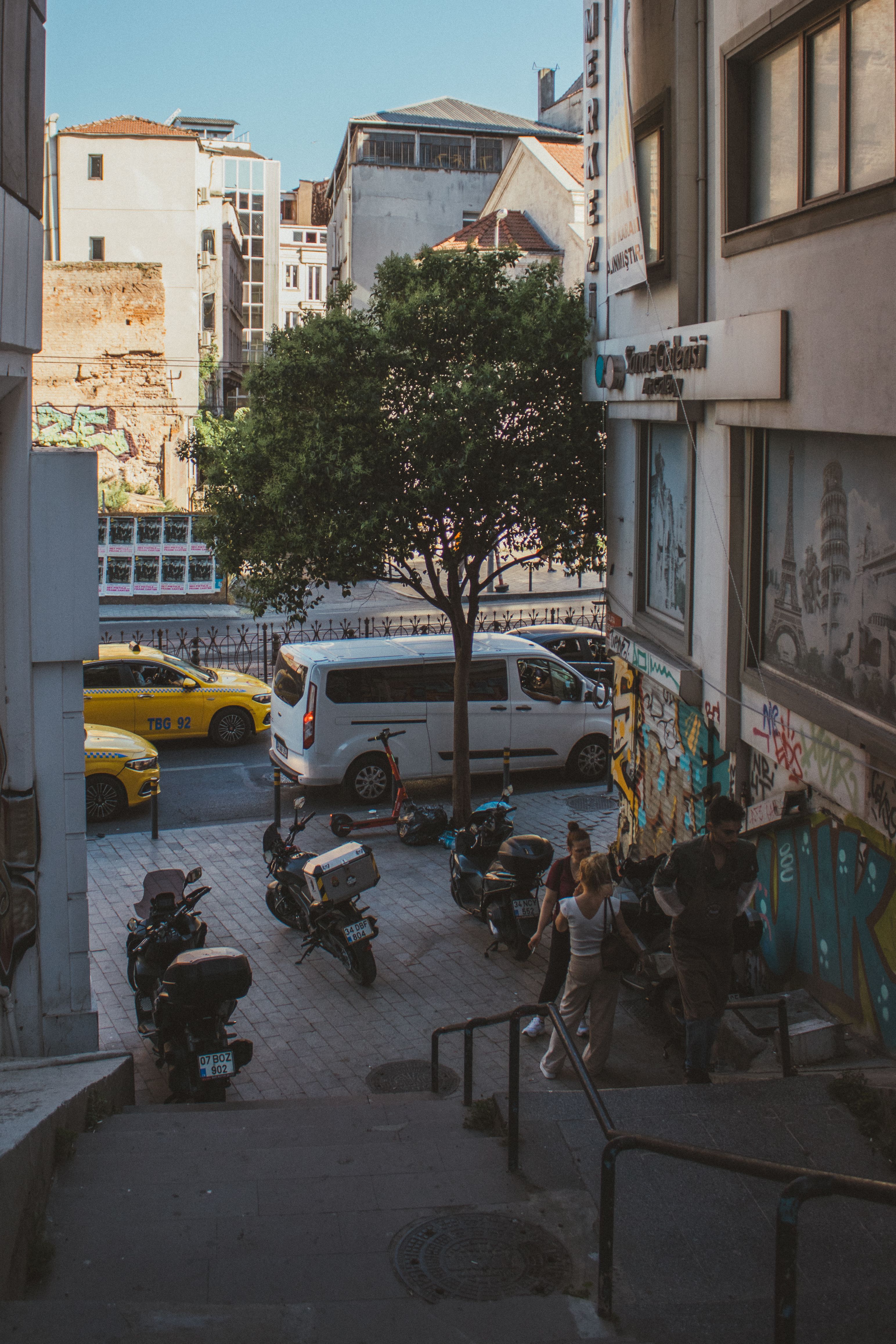Dynamic city street with motorbikes, taxis, and pedestrians showcasing urban lifestyle.